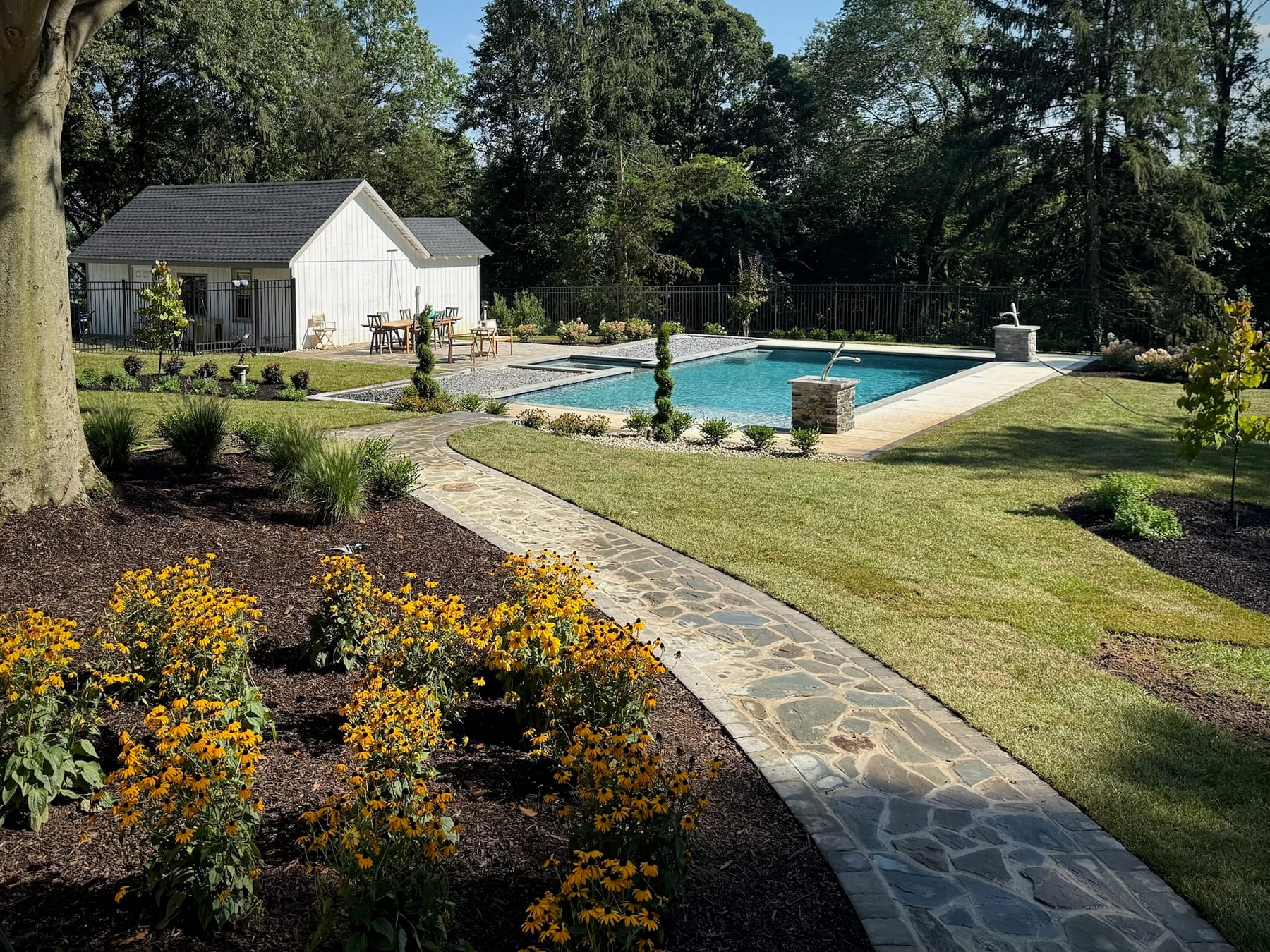 Backyard pool with flagstone walkway and bordering garden beds